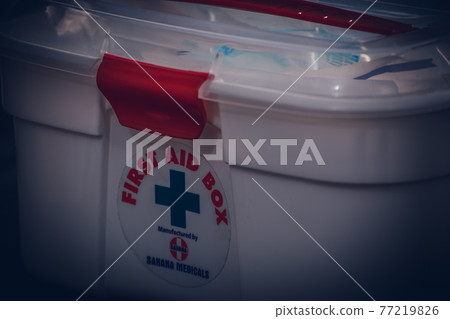 First aid box on a green-clothed tabletop front view close-up image. easy and handy portable medical treatment box. 77219826