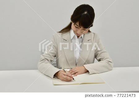 Woman taking notes 77221473