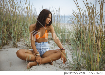 Boho Woman on the Beach near the Sea Boho Woman on the Beach near the Sea 77227670