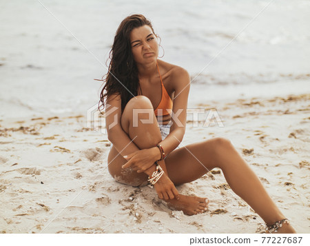 Bored Woman on the Beach near the Sea Bored Woman on the Beach near the Sea 77227687