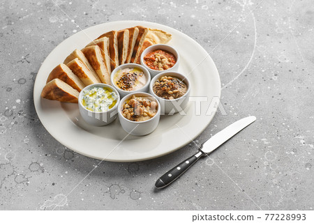 Mediterranean snack set. Hummus, olives, peppers, yogurt, beans. Greek cuisine. Assorted. Place for text Mediterranean snack set. Hummus, olives, peppers, yogurt, beans. Greek cuisine. Assorted. Place for text 77228993