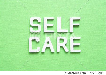 Self care word abstract quote on wooden blocks over green background. 77229206