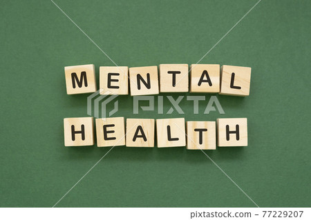 Mental health word isolated text on wooden blocks over green background. 77229207