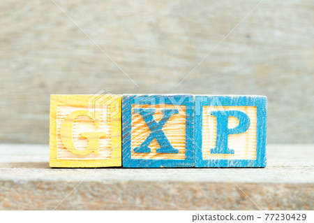 Color alphabet letter block in word GXP on wood background Color alphabet letter block in word GXP on wood background 77230429