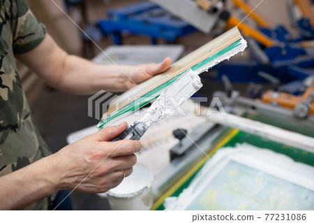 Serigraphy silk screen print process at clothes factory. Cleansing Frame, squeegee and plastisol color paints 77231086