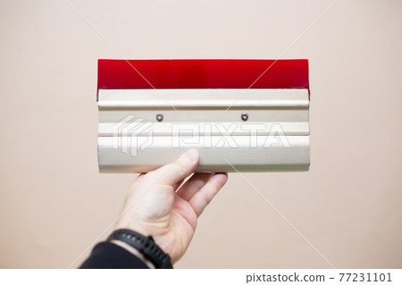 Hand with squeegee for serigraphy silk screen print process at clothes factory. Hand with squeegee for serigraphy silk screen print process at clothes factory. 77231101