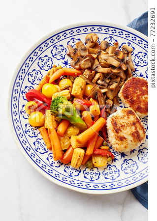 Plate with fried vegetables, carrots, broccoli, baby corn, bell peppers, roasted champignons and two chicken balls Plate with fried vegetables, carrots, broccoli, baby corn, bell peppers, roasted champignons and two chicken balls 77232691
