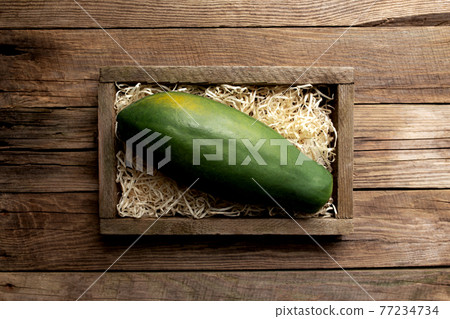 Fresh tropical papaya fruit in a wooden box on a wooden background 77234734