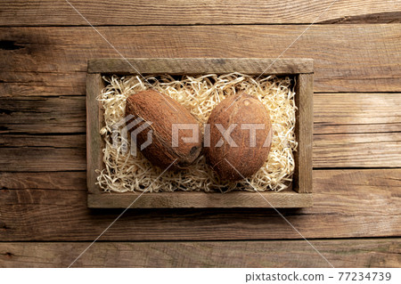 Fresh tropical fruits in a wooden box on a wooden background 77234739