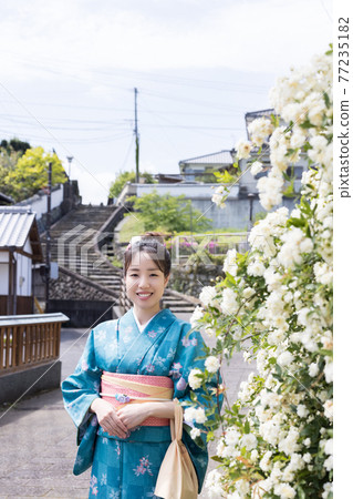 A young woman in a kimono taking a commemorative photo with the slope of Ameya in the background [Kitsuki City] 77235182