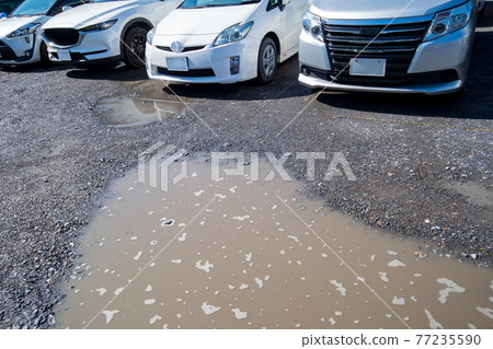 Puddle in a gravel parking lot 77235590