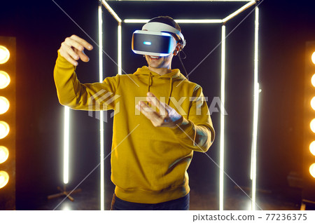 Gamer plays simulator in virtual reality headset 77236375