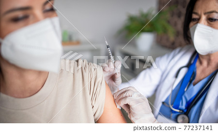 Woman with respirator getting vaccinated in hospital, coronavirus and vaccination concept. Woman with respirator getting vaccinated in hospital, coronavirus and vaccination concept. 77237141