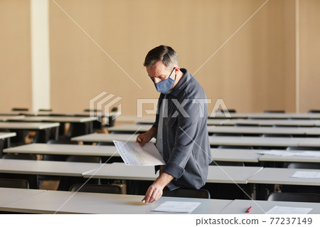 College professor laying out exam papers 77237149