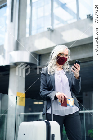 Senior woman in airport lounge, coronavirus, travel and new normal. 77237224