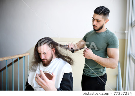 Haircut in corridor in block of flats at home, coronavirus and lockdown concept. Haircut in corridor in block of flats at home, coronavirus and lockdown concept. 77237254