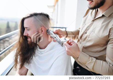 Haircut on balcony at home, coronavirus and lockdown concept. 77237265