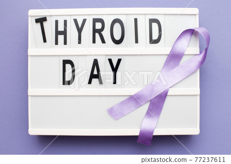 inscription international thyroid day and violet ribbon on purple background inscription international thyroid day and violet ribbon on purple background 77237611