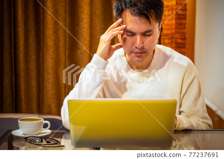 headache, tense young asian man working on laptop computer in bedroom at night headache, tense young asian man working on laptop computer in bedroom at night 77237691