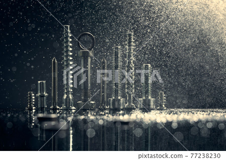 Abstract panorama of city illuminated by bright light with reflection, made by metal bolt and nut chrome. Black background with bokeh. 77238230