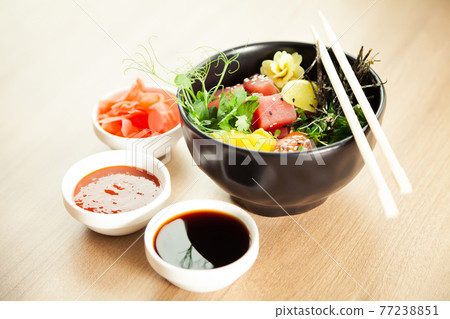 Poke salad with tuna in a bowl. Ingredients fresh tuna, cherry tomatoes, marinated seaweed, rice 77238851