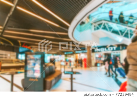 Shopping mall entrance blurred background. People shopping in modern commercial mall center. Interior of retail centre store in soft focus. Image for background use. 77239494