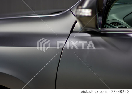 Installation of a protective paint and varnish matte film on the car. The PPF polyurethane film protects the car paint from stones and scratches, blurry focus. Chelyabinsk, Russia, April 03, 2021 77240220
