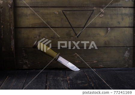 Scandinavian Swedish knife on the background of a green army box. 77241169