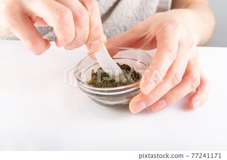 Mix cosmetics in a glass container. Green powder in a glass dish. Mix cosmetics in a glass container. Green powder in a glass dish. 77241171