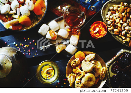 Eastern table. Dried fruits. Mix of nuts, dried apricots, Turkish delight, dates, figs, sweets. Eastern table. Dried fruits. Mix of nuts, dried apricots, Turkish delight, dates, figs, sweets. 77241209
