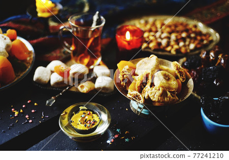 Eastern table. Dried fruits. Mix of nuts, dried apricots, Turkish delight, dates, figs, sweets. Eastern table. Dried fruits. Mix of nuts, dried apricots, Turkish delight, dates, figs, sweets. 77241210