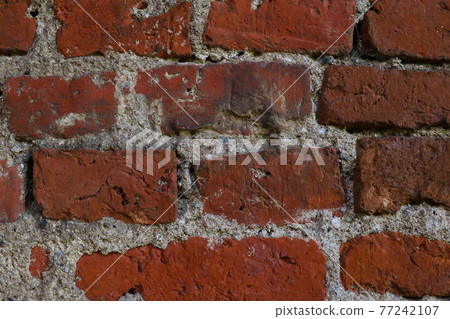 The wall of an old red brick building. 77242107