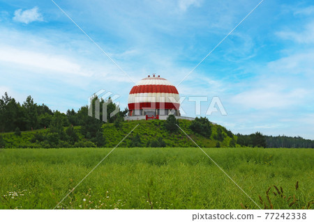 View of a beautiful domed structure in greenery. 77242338