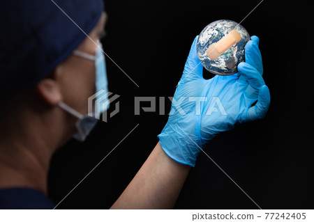 Nurse or Doctor Wearing Face Mask and Surgical Gloves Holding Bandaged Planet Earth Nurse or Doctor Wearing Face Mask and Surgical Gloves Holding Bandaged Planet Earth 77242405