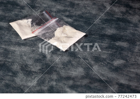 Transparent plastic bags with white powder, cocaine,speed or other drugs on gray background with copy space, dealing,drug,junky,addiction concept Transparent plastic bags with white powder, cocaine,speed or other drugs on gray background with copy space, dealing,drug,junky,addiction concept 77242473