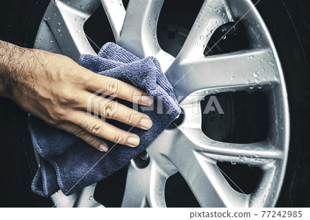 Human hand is wipe the alloy wheel of the car with a microfiber cloth Human hand is wipe the alloy wheel of the car with a microfiber cloth 77242985