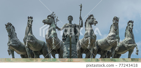 Statues of 6 horses and Goddess Victoria at the top of Triumphal Arch called Arch of Peace (Porta Sempione) in Milan historical downtown, Sempione Park, Italy. 77243418