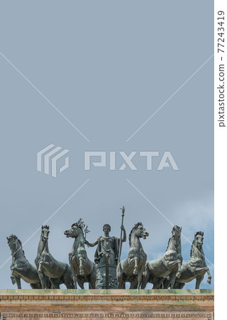 Statues of 6 horses and Goddess Victoria at the top of Triumphal Arch called Arch of Peace (Porta Sempione) in Milan historical downtown, Sempione Park, Italy, with copy space.. 77243419