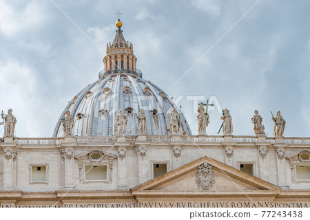 Dramatic view over Saint Peter Basilica in Vatican city, in the center of Rome, Italy, with heavy clouds. 77243438
