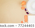 top view travel beach background concept with sunglasses ,orange juice , sunscreen and beach hat on sand. 77244403
