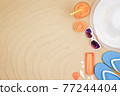 top view travel beach background concept with sunglasses ,orange juice , sunscreen and beach hat on sand. 77244404