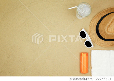 top view a hat , sunglasses ,shoes and water drink on sand beach. top view a hat , sunglasses ,shoes and water drink on sand beach. 77244405