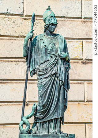 Old statue of a Roman armed soldier with spear and helmet, and a snake at his foot in Potsdam, a German town of statues and sculptures, Germany 77244552