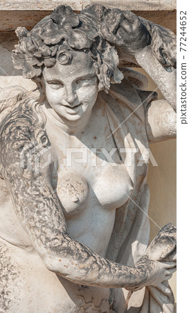 Wall sculpture of sensual Rococo Era woman in city park and historical downtown of Potsdam, Germany, details, closeup. Wall sculpture of sensual Rococo Era woman in city park and historical downtown of Potsdam, Germany, details, closeup. 77244652