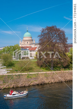 Historical downtown in Potsdam with river Havel and Saint Nikolai cathedral at blue sky in Spring, Germany 77244681