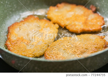 Potato pancakes on the frying pan Potato pancakes on the frying pan 77244735