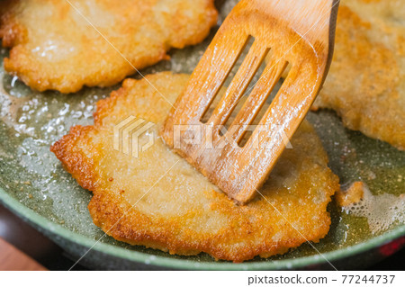 Potato pancakes on ceramic green frying pan Potato pancakes on ceramic green frying pan 77244737