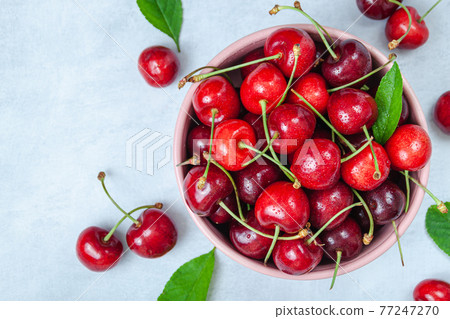 Cherry with leaf on plate and water dropsand on grey stone table 77247270