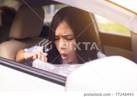 Asian woman puke or vomiting into plastic bag in car,Car Sick and motion sickness Asian woman puke or vomiting into plastic bag in car,Car Sick and motion sickness 77248443