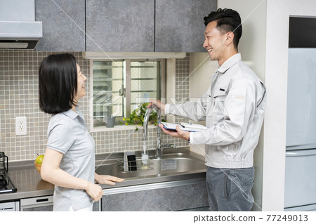 A man in work clothes explaining to a woman (water crew) A man in work clothes explaining to a woman (water crew) 77249013